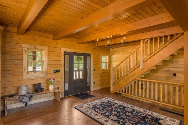 entryway with beam ceiling, dark hardwood / wood-style flooring, wooden ceiling, and wood walls