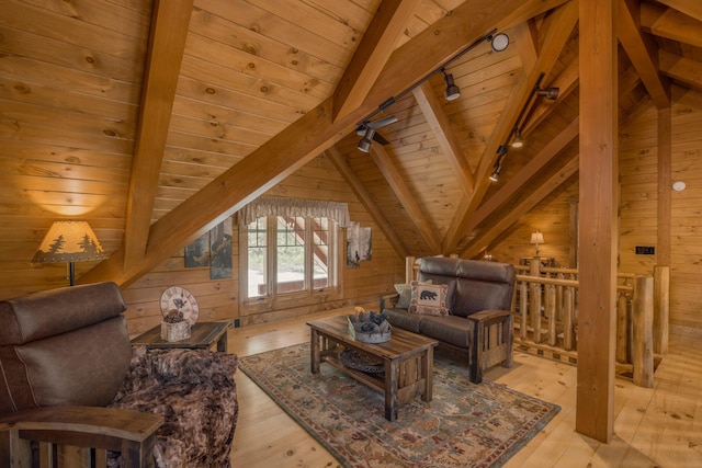 sitting room featuring track lighting, lofted ceiling with beams, wooden walls, and light hardwood / wood-style flooring