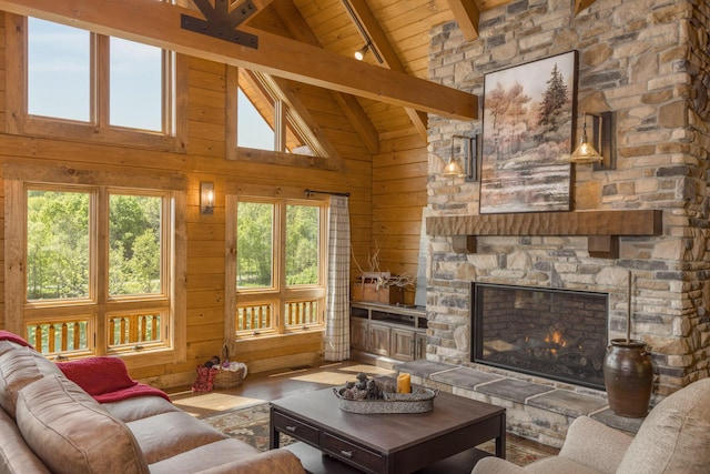 living room with wooden ceiling, high vaulted ceiling, a stone fireplace, beamed ceiling, and wood-type flooring