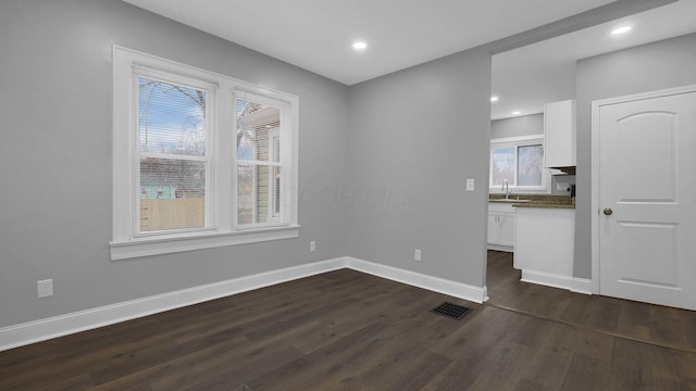 spare room featuring sink and dark hardwood / wood-style floors