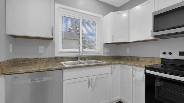 kitchen featuring sink, white cabinets, dark stone counters, and appliances with stainless steel finishes