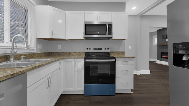 kitchen with dark hardwood / wood-style flooring, stainless steel appliances, white cabinetry, and sink