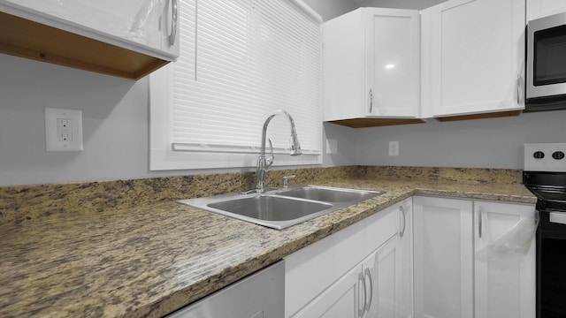 kitchen featuring white cabinetry, sink, light stone countertops, and electric range oven