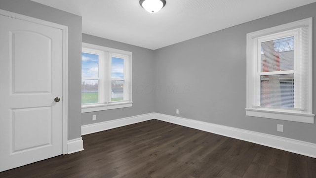 empty room with dark hardwood / wood-style flooring