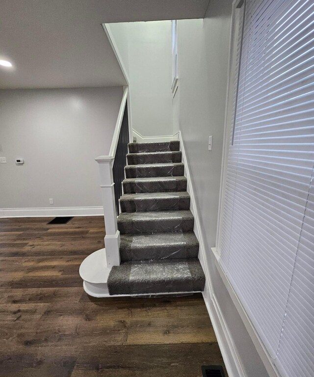 staircase with hardwood / wood-style floors