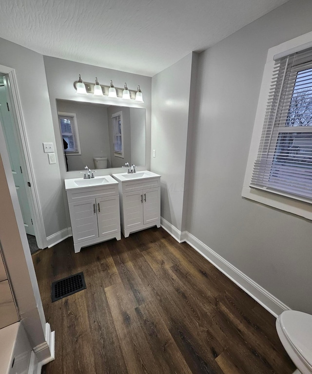 bathroom featuring hardwood / wood-style floors, vanity, a textured ceiling, and toilet