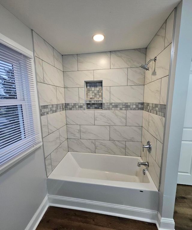 bathroom featuring tiled shower / bath combo and wood-type flooring