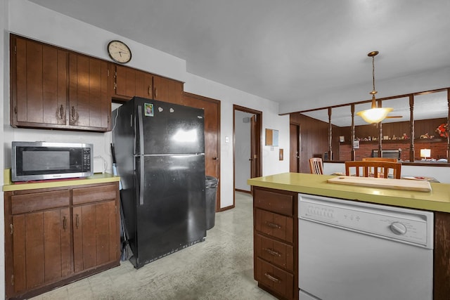 kitchen with black refrigerator, white dishwasher, and hanging light fixtures