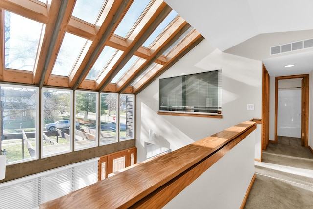 interior space featuring light colored carpet and vaulted ceiling