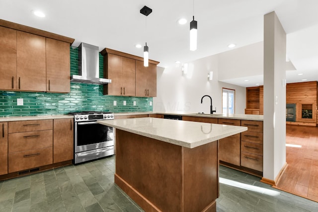 kitchen with wall chimney exhaust hood, stainless steel range, dark wood-type flooring, sink, and hanging light fixtures