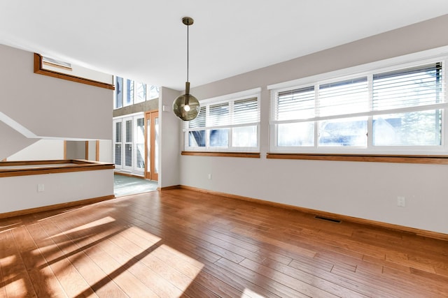 unfurnished room with wood-type flooring and a wealth of natural light