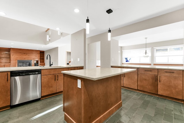 kitchen with dishwasher, sink, hanging light fixtures, a kitchen island, and light stone counters