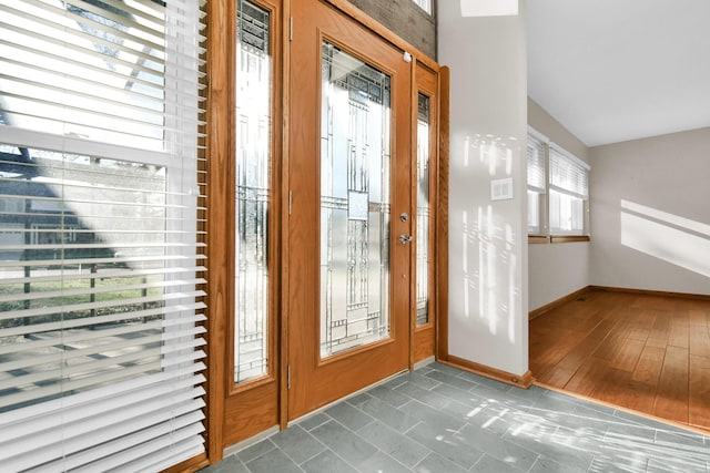 entryway with dark wood-type flooring and lofted ceiling