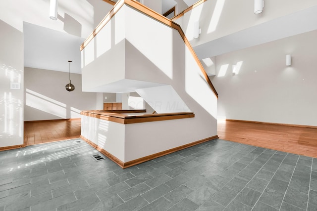 stairs with hardwood / wood-style floors and a high ceiling