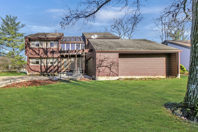 rear view of property featuring a lawn and a sunroom