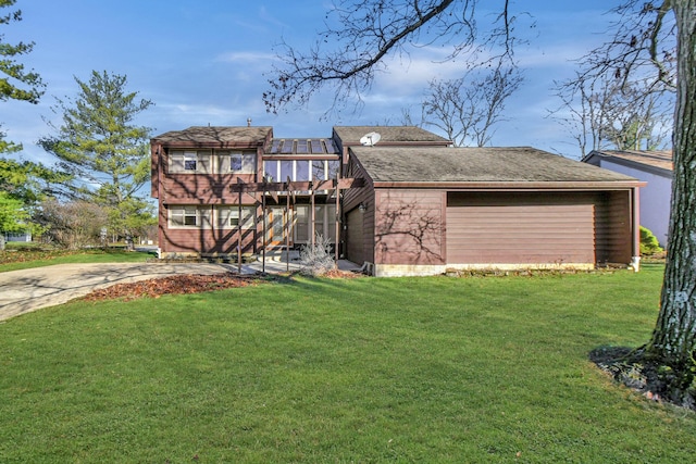 back of property featuring a garage and a lawn