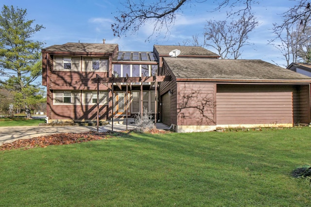 rear view of property with a yard and a sunroom