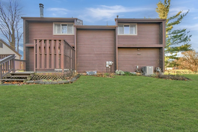 rear view of property with a yard and central air condition unit