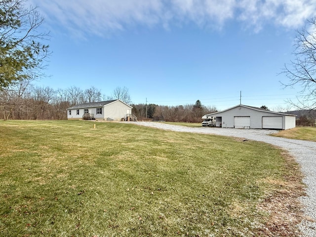 view of yard featuring a garage and an outbuilding