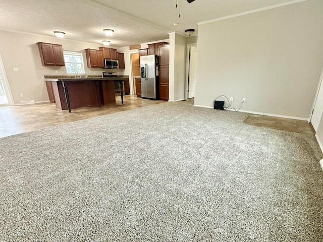 kitchen with a kitchen breakfast bar, a kitchen island, a textured ceiling, and appliances with stainless steel finishes