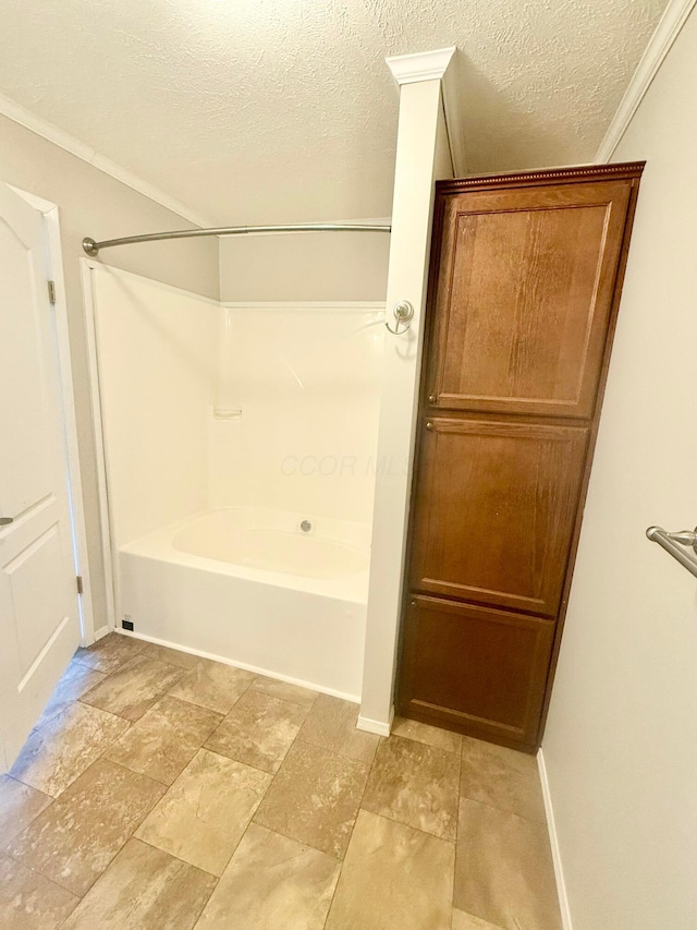 bathroom with a textured ceiling and shower / washtub combination