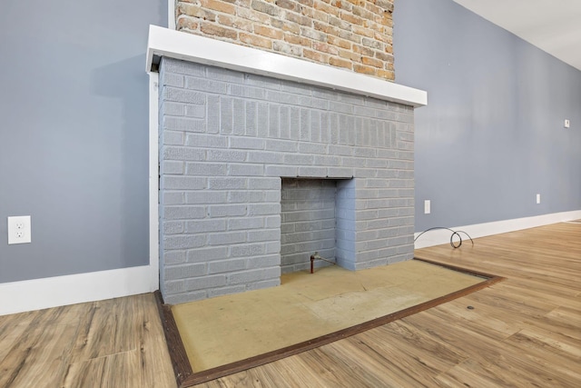 details with hardwood / wood-style floors and a brick fireplace