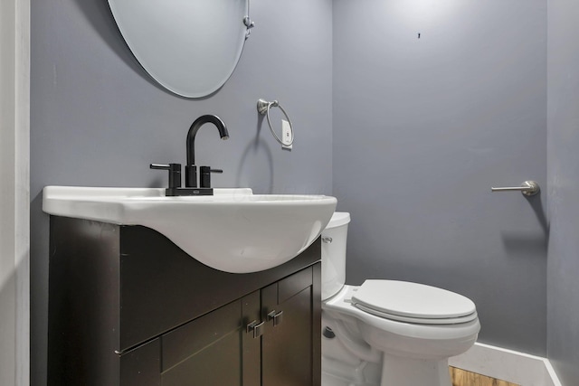 bathroom with vanity, toilet, and wood-type flooring