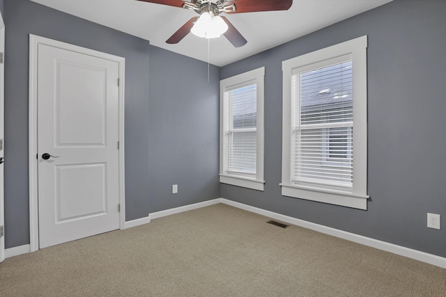 carpeted spare room featuring ceiling fan