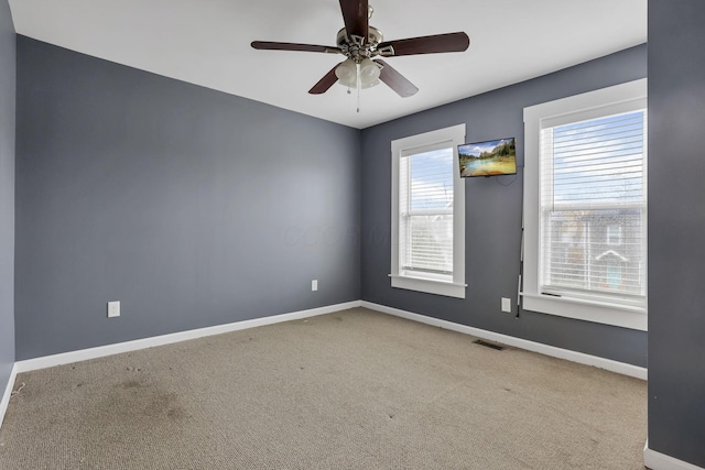 empty room with ceiling fan, carpet, and a healthy amount of sunlight