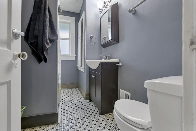 bathroom with tile patterned flooring, vanity, and toilet