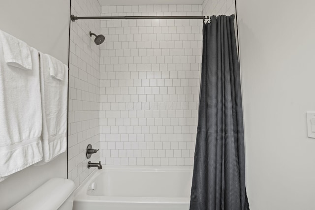 bathroom with shower / bath combination with curtain and toilet