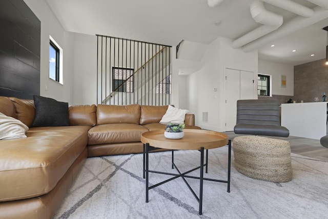 living room featuring beam ceiling and light wood-type flooring