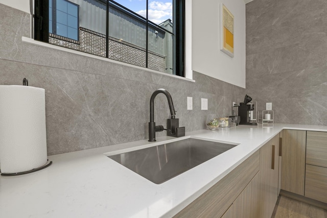 kitchen featuring tile walls and sink