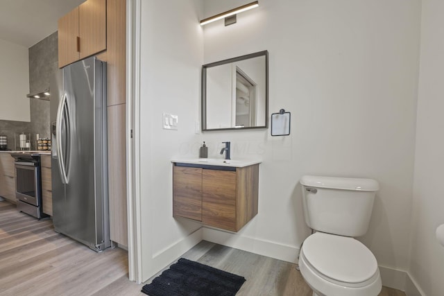 bathroom with vanity, toilet, wood-type flooring, and backsplash