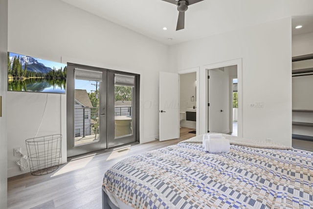 bedroom featuring access to exterior, french doors, ensuite bathroom, ceiling fan, and light hardwood / wood-style flooring