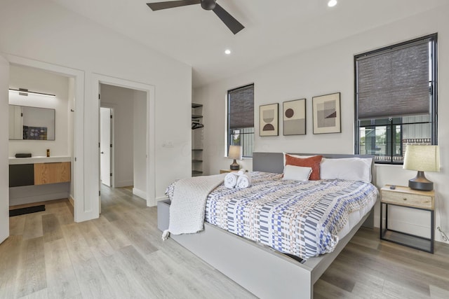 bedroom with light hardwood / wood-style floors, ceiling fan, and ensuite bathroom