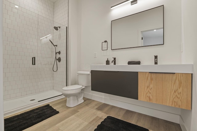 bathroom featuring hardwood / wood-style floors, vanity, toilet, and an enclosed shower