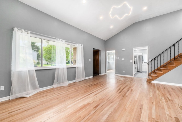 1677 Kenview Rd, Columbus, OH 43209 - unfurnished living room with stairs, wood finished floors, high vaulted ceiling, baseboards, and recessed lighting