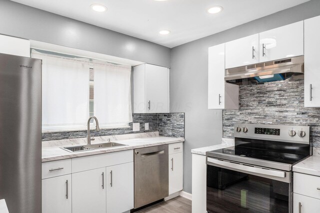 1677 Kenview Rd, Columbus, OH 43209 - kitchen featuring white cabinets, a sink, stainless steel appliances, decorative backsplash, and under cabinet range hood