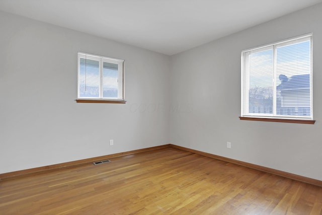 unfurnished room featuring plenty of natural light and light hardwood / wood-style flooring