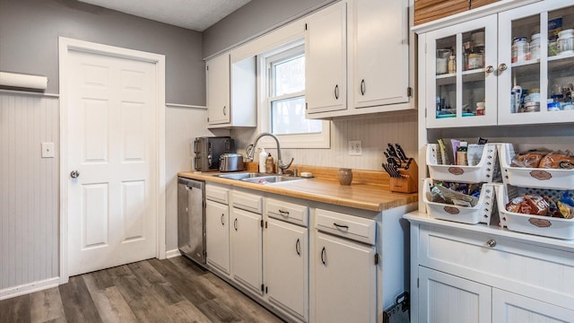 kitchen featuring stainless steel dishwasher, white cabinetry, sink, and dark wood-type flooring