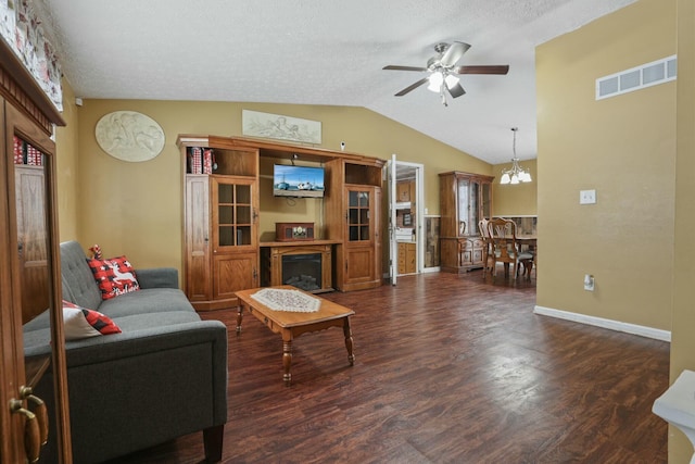 living room featuring a textured ceiling, ceiling fan with notable chandelier, dark hardwood / wood-style floors, and lofted ceiling