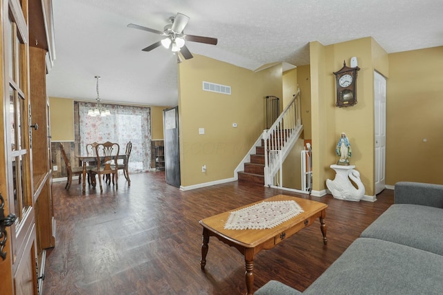 living room featuring a textured ceiling, ceiling fan with notable chandelier, vaulted ceiling, and dark wood-type flooring