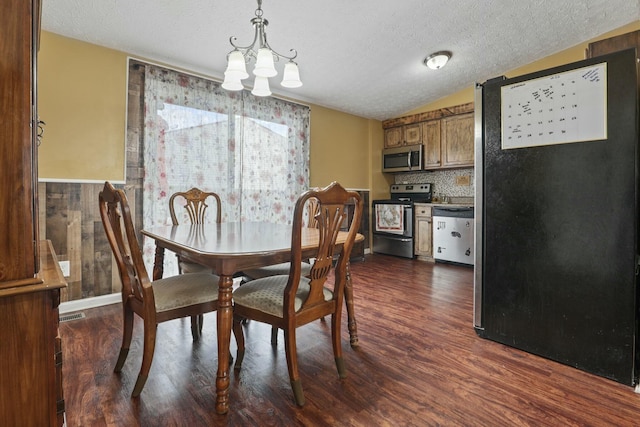 dining space featuring a notable chandelier, vaulted ceiling, dark hardwood / wood-style floors, and a textured ceiling