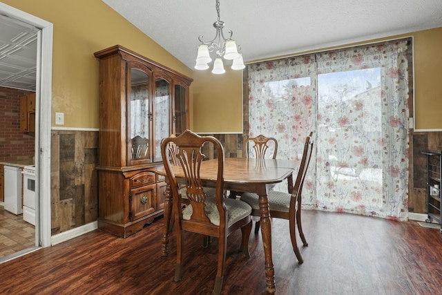 dining area featuring lofted ceiling, dark hardwood / wood-style floors, and an inviting chandelier