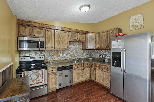 kitchen featuring dark wood-type flooring, sink, vaulted ceiling, decorative backsplash, and appliances with stainless steel finishes