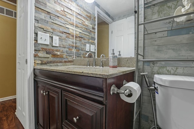 bathroom with vanity, wood-type flooring, and toilet