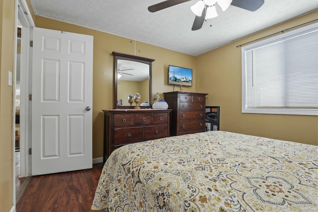 bedroom featuring ceiling fan, dark hardwood / wood-style floors, and a textured ceiling