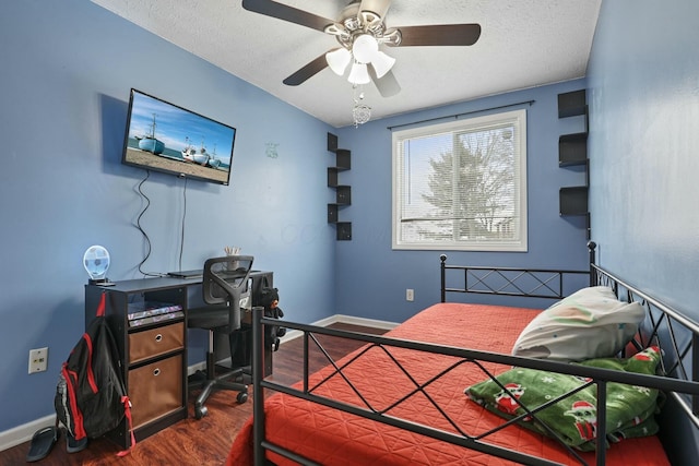 bedroom with ceiling fan, dark hardwood / wood-style floors, and a textured ceiling