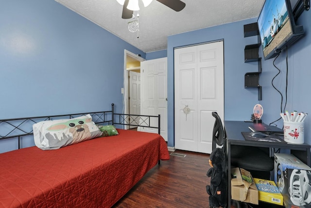 bedroom featuring a textured ceiling, a closet, ceiling fan, and dark wood-type flooring